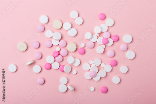 Pink and white pills on pink background. Heap of assorted various medicine tablets and pills. Health care.