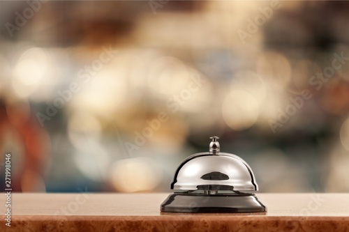 Vintage hotel reception service desk bell on blurred background, bokeh