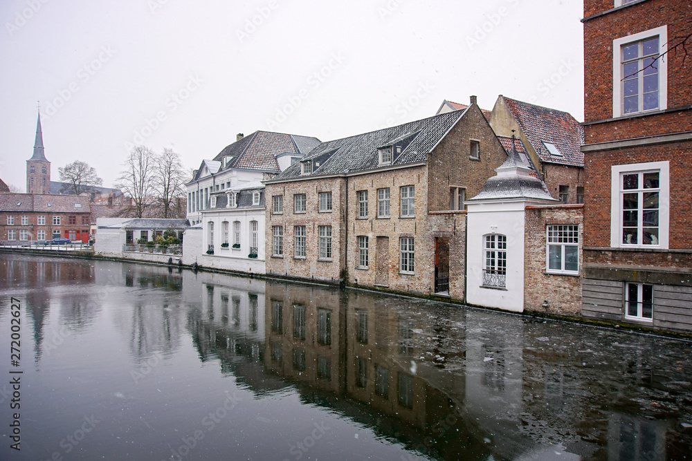 A reflection of houses and cathedrals in the river in Bruges, Belgium.
