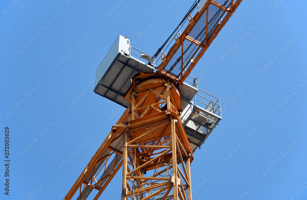 Naklejka premium Construction tower crane against the blue sky. Fragment
