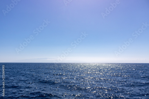 Seascape with sea horizon and almost clear deep blue sky