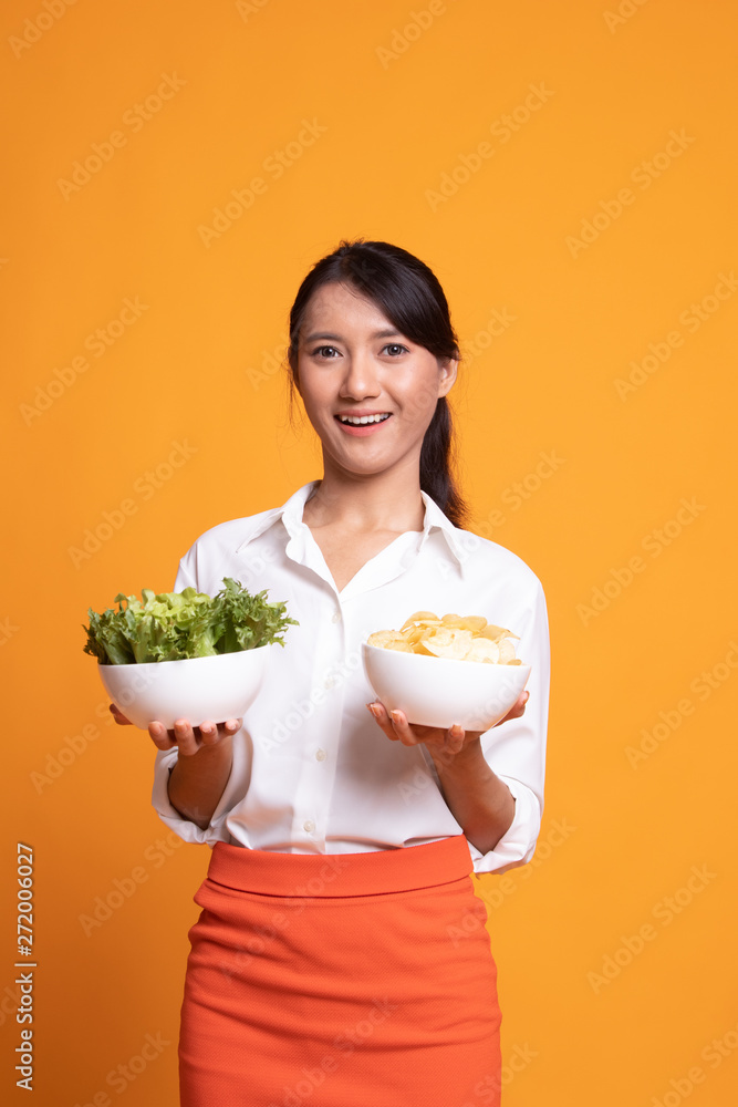 Young Asian woman with potato chips and salad. Young Asian woman with potato chips and salad.