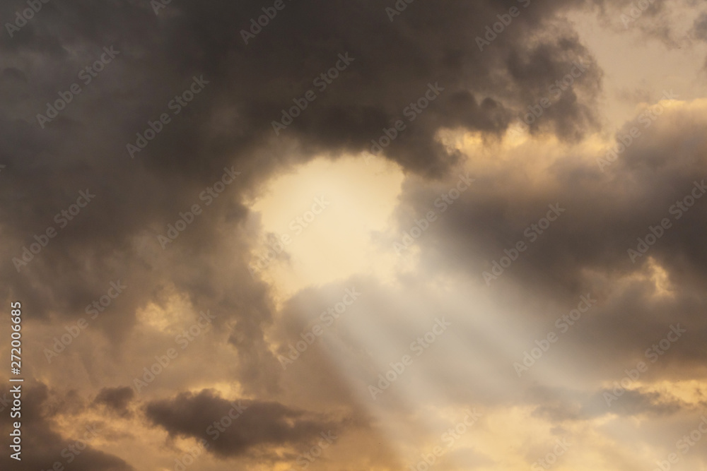Sunlight penetrates through thick dark clouds during the sunset_ Sunlight penetrates through thick dark clouds during the sunset_