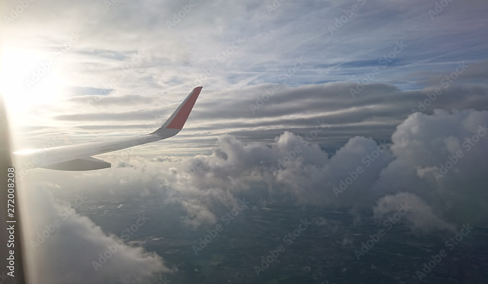 wing of airplane flying above clouds wing of airplane flying above clouds
