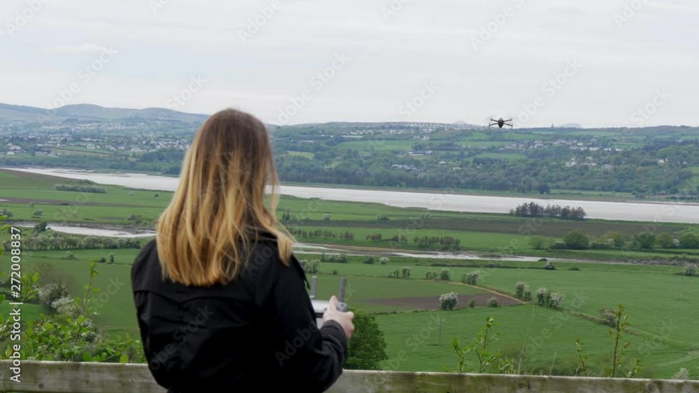 Young woman flying a drone in Ireland - travel photography Young woman flying a drone in Ireland - travel photography