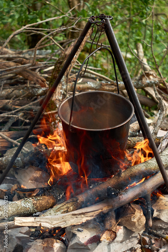 Cooking food in a saucepan over an open fire in nature 