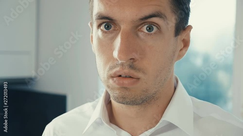 Portrait of young man is surprised and takes off his glasses in shock. He is worried about seeing