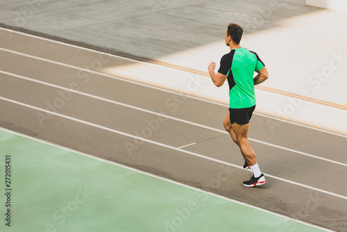 full length view of mixed race sportsman running at stadium