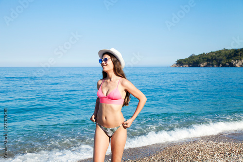 Beautiful young woman in sexy bikini standing at sea beach © busra