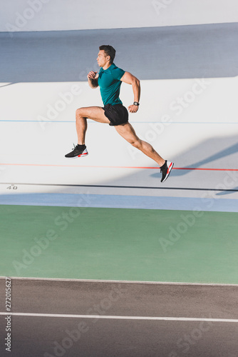 side view of muscular mixed race sportsman sprint running at stadium © LIGHTFIELD STUDIOS