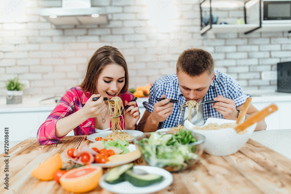 Portrait of cute happy in cheeful action tasting and smelling breakfast of macaroni table decorated with ingredient of food in modern kitchen.. Portrait of cute happy in cheeful action tasting and smelling breakfast of macaroni table decorated with ingredient of food in modern kitchen..