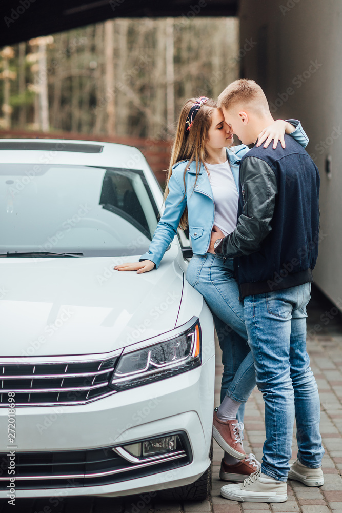 Young and lovely person stay near modern super car in the house gaden. Young and lovely person stay near modern super car in the house gaden.