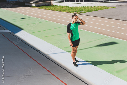 full length view of mixed race sportsman standing at stadium