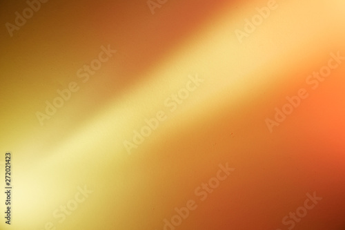 Yellow diagonal beam of light on an orange and dark orange background