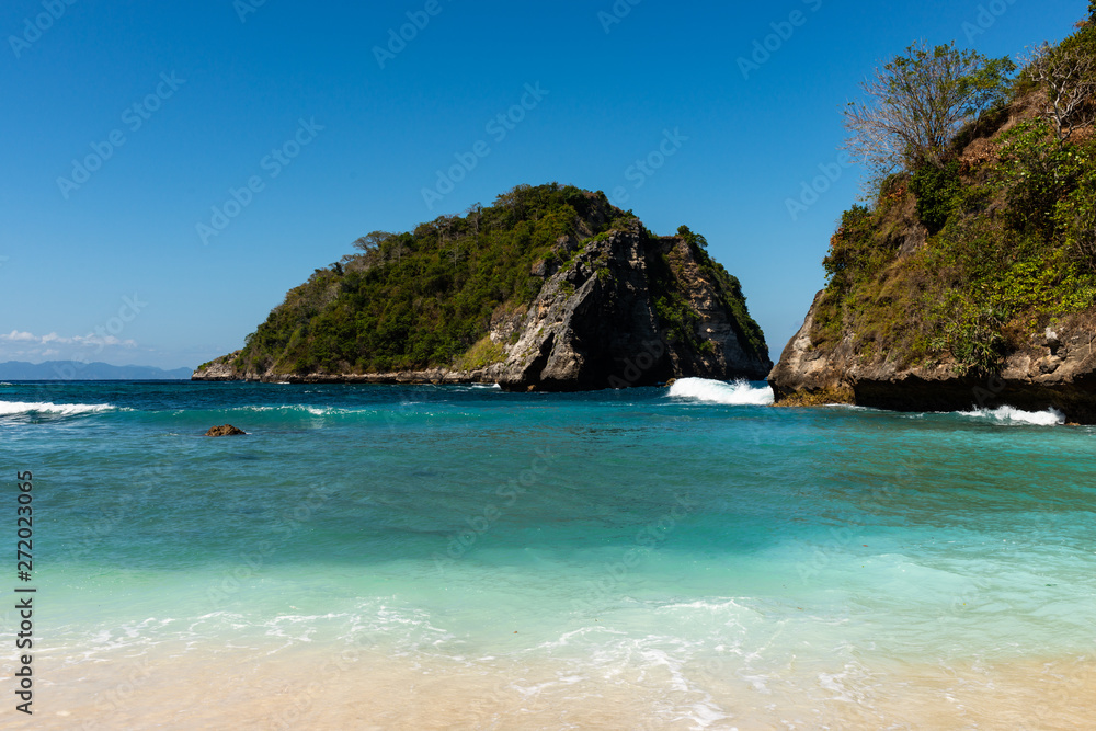 View of tropical beach, sea rocks and turquoise ocean, blue sky. Atuh Beach, Nusa Penida, Indonesia. View of tropical beach, sea rocks and turquoise ocean, blue sky. Atuh Beach, Nusa Penida, Indonesia.