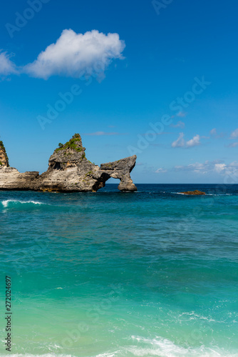 View of tropical beach, sea rocks and turquoise ocean, blue sky. Atuh Beach, Nusa Penida, Indonesia.
