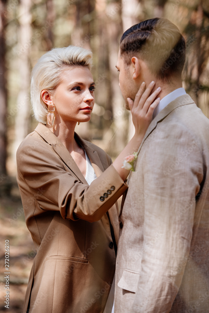 Fototapeta premium Selective focus of stylish woman touching man face