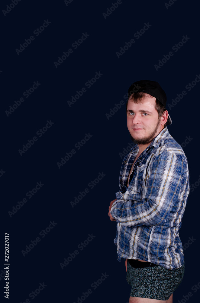 Cute man in a blue shirt, naked body, blue background.