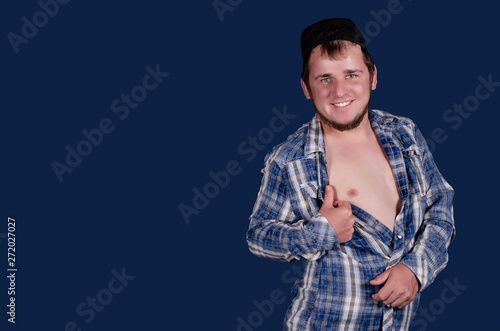 Cute man in a blue shirt, naked body, blue background.