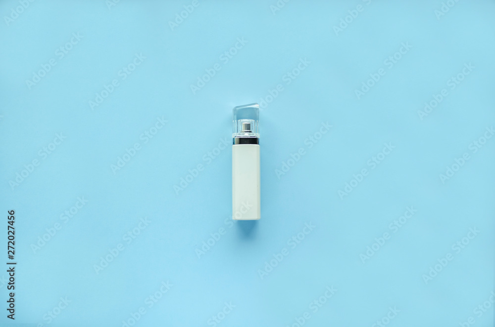 White bottle of perfume with a transparent cap on a blue background. soft focus. copy space. isolated. White bottle of perfume with a transparent cap on a blue background. soft focus. copy space. isolated.