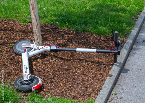 Modern сity transport - electric scooters is lying on the lawn.