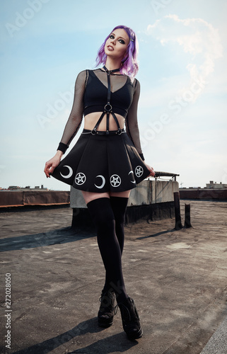 Portrait of lovely gothic girl on roof. Pastel goth with violet (pink) hair  in black clothes ภาพถ่ายสต็อก