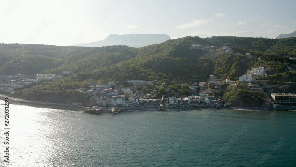 Aerial of a small village on Alushta municipality coast of Crimea with a bird flying through Aerial of a small village on Alushta municipality coast of Crimea with a bird flying through
