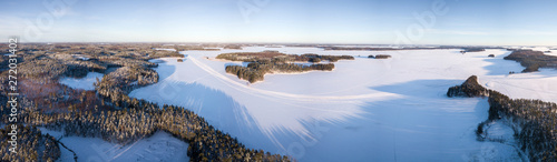 Aerial panorama of frozen lake with snowmobile routes