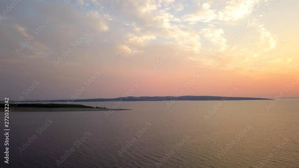 Panoramic view of high flying drone showing burning sky at golden hour of sunset over island Pasman and mainland in background. Panoramic view of high flying drone showing burning sky at golden hour of sunset over island Pasman and mainland in background.