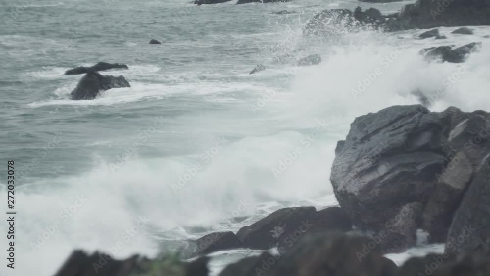 Overcast rugged rocky coastline hit by violent crashing waves in dramatic storm impact. Overcast rugged rocky coastline hit by violent crashing waves in dramatic storm impact.