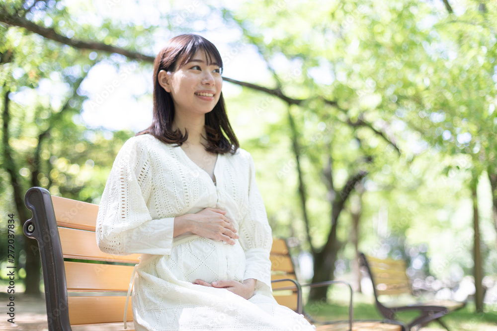 公園のベンチに座るに妊婦 公園のベンチに座るに妊婦