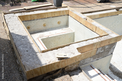 Empty swimming pool under remodel with wooden forms for new tile and coping and concrete