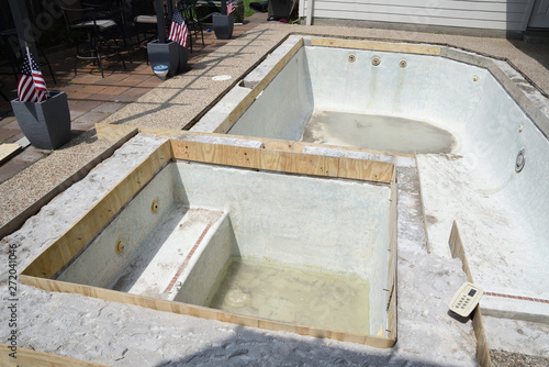 Empty swimming pool under remodel with wooden forms for new tile and coping and concrete
