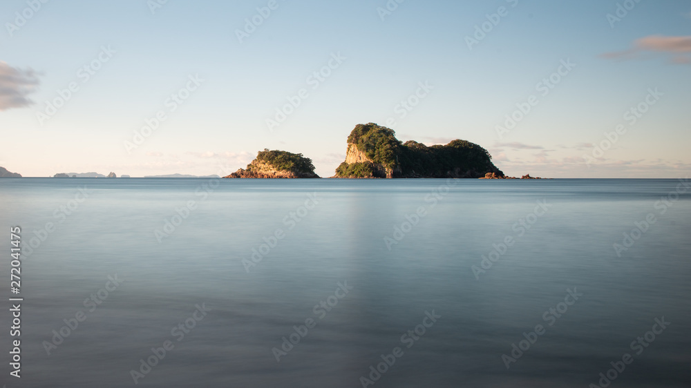 Fototapeta premium Long exposure photo of small islands at sunset off the coast of the Cathedral Cove on the Coromandel Peninsula, New Zealand