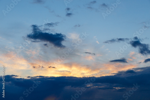 Beautiful sunset. Colorful dramatic sky at sunset. Layered-rain and Cirrus Cumulus clouds. Blue blue background with setting sun. The texture of the sunset.