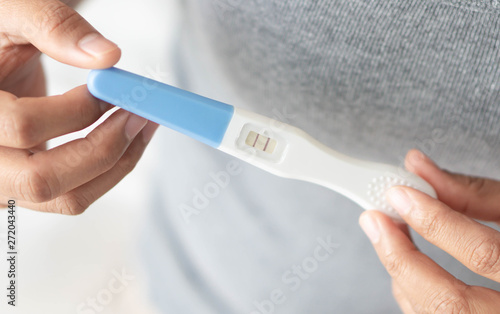 Closeup woman hand holding pregnancy test with happy moment  health care concept  selective focus