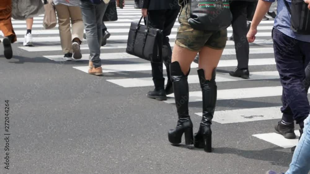 Zooming into the crosswalk in the city center of Tokyo, Japan (Shibuya) while many salary man and woman crossing the Tokyo crosswalk in daytime - legs and feet while crossing road in Tokyo,Japan Zooming into the crosswalk in the city center of Tokyo, Japan (Shibuya) while many salary man and woman crossing the Tokyo crosswalk in daytime - legs and feet while crossing road in Tokyo,Japan