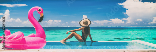 Vacation swimming pool banner luxury travel background woman relaxing by infinity overwater bungalow with pink flamingo float fun holiday concept panorama. © Maridav