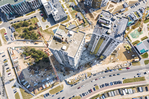 civil construction site. aerial top view of new apartment buildings in progress and yellow tower cranes