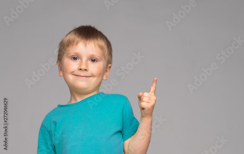 Portrait of happy smiling boy in blue t-shirt. Attractive kid in studio.