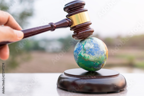 Earth destruction and destroy environmental by hand human concept. Judge gavel / world model should have legal force or certification for survival of all mankind with international Environment law photo