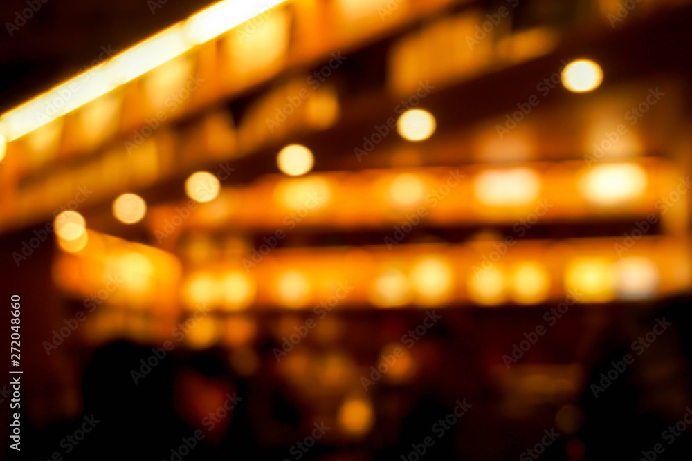 Closeup blurred of restaurant ceiling and bokeh refection lighting with yellow warm lights.