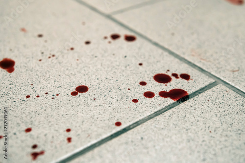 Conceptual image with blood on it resting on tiles on floor