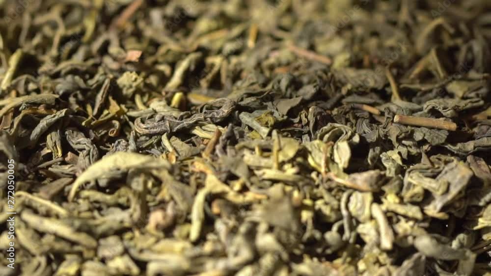 SLOW MOTION: Tea leaves fall on a pile of a green tea - Macro shot. Beautiful view. SLOW MOTION: Tea leaves fall on a pile of a green tea - Macro shot. Beautiful view.
