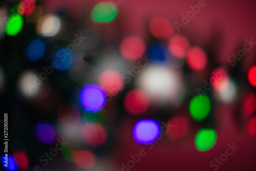 The Christmas tree is lit in different colors. Blurred background of the new year holiday