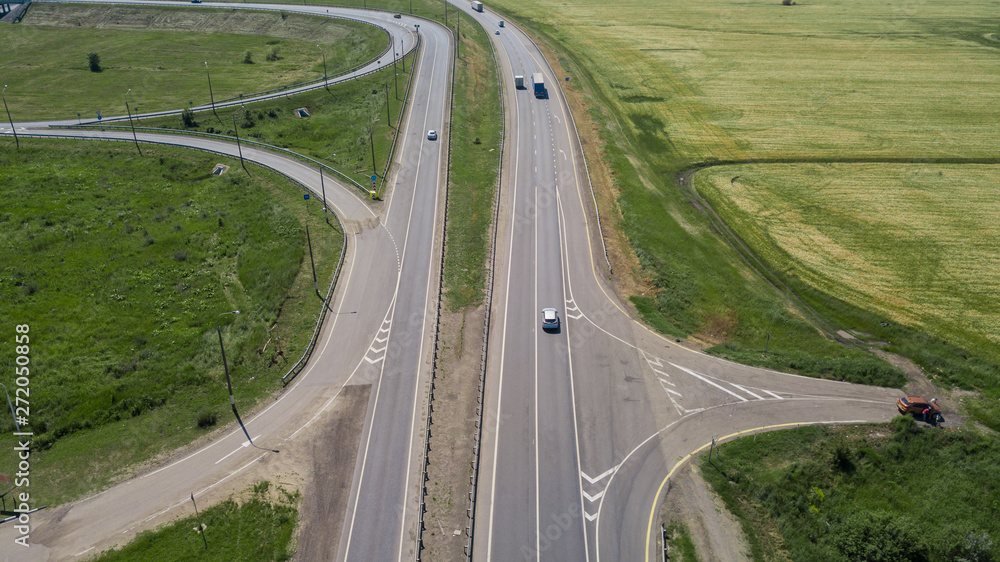 Aerial view of modern highway road intersection on rural landscape