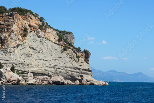 Rocks near the coast of the Mediterranean sea on a background of mountains in Turkey