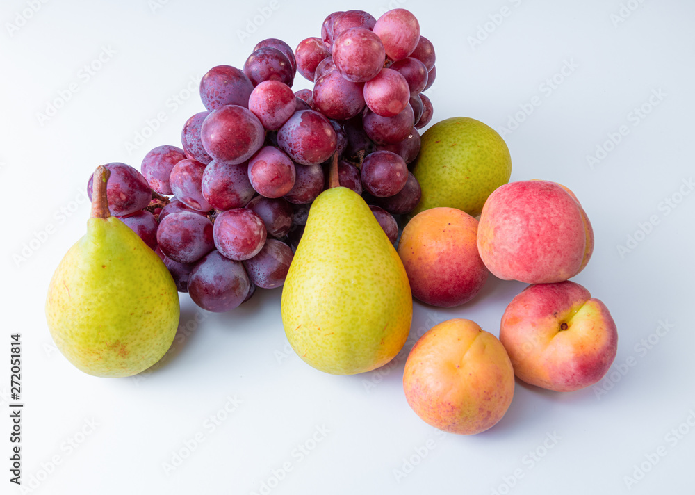 Different fresh fruits. A bunch of grapes, pears, nectarines. soft textures of fruits on a white background Different fresh fruits. A bunch of grapes, pears, nectarines. soft textures of fruits on a white background