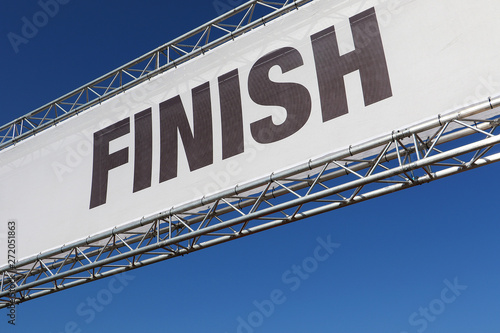 Finish line banner across a clear blue sky
