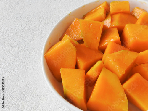 High angle view of a plate of fresh yellow diced mango isolated on white background. Mango is a common fruit in Taiwan during the summer. Summer, fruit, agriculture concept. With copy space.